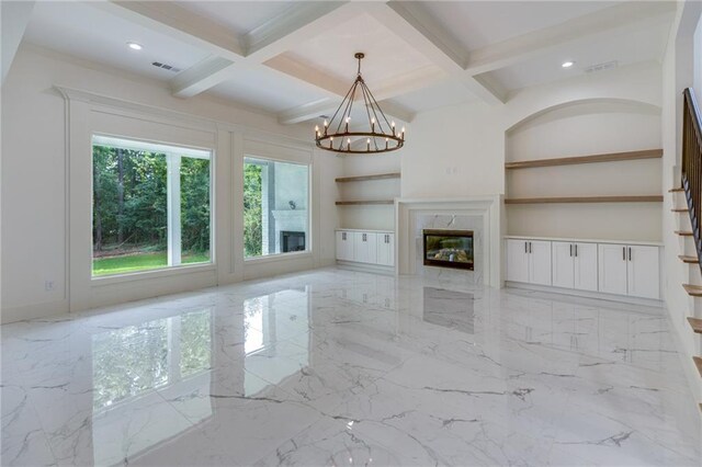 unfurnished living room featuring beamed ceiling, an inviting chandelier, coffered ceiling, and a premium fireplace