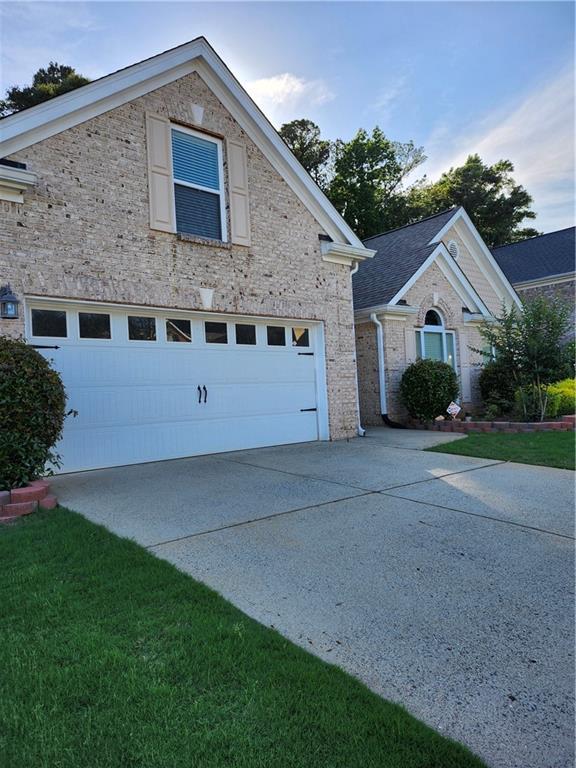 979 Simonton Glen Dr, Lawrenceville, GA 30045 - view of front of property with an attached garage, concrete driveway, brick siding, and stone siding