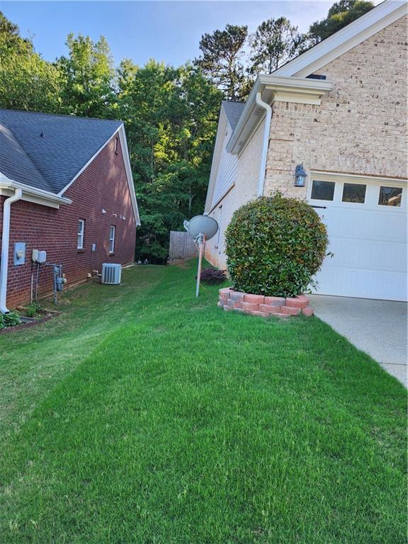 979 Simonton Glen Dr, Lawrenceville, GA 30045 - view of green lawn featuring a garage