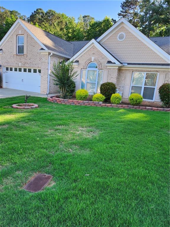 979 Simonton Glen Dr, Lawrenceville, GA 30045 - view of front of property featuring a garage, brick siding, and a front yard