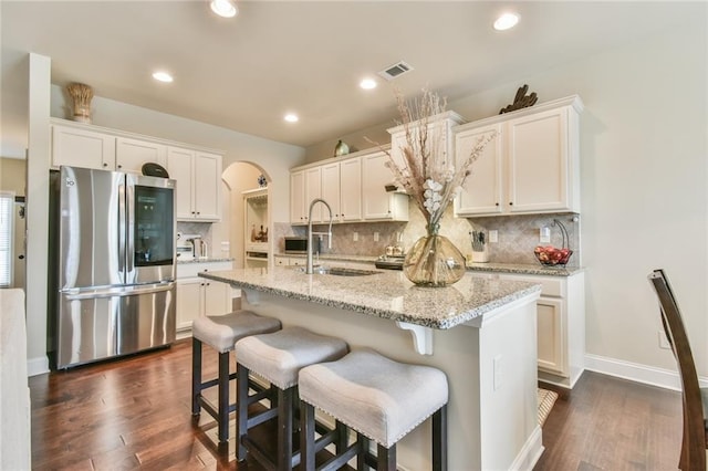 kitchen featuring visible vents, arched walkways, a sink, dark wood-type flooring, and smart refrigerator