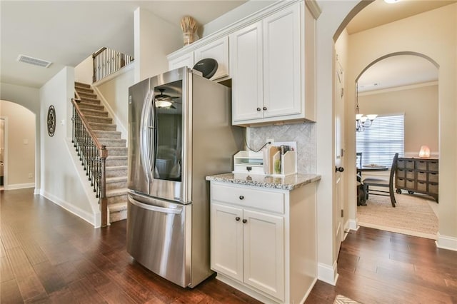 kitchen featuring visible vents, light stone countertops, dark wood finished floors, smart refrigerator, and arched walkways