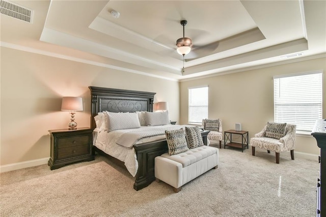 bedroom featuring visible vents, baseboards, a tray ceiling, and carpet floors