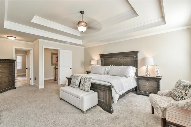 carpeted bedroom with a raised ceiling, a ceiling fan, and crown molding