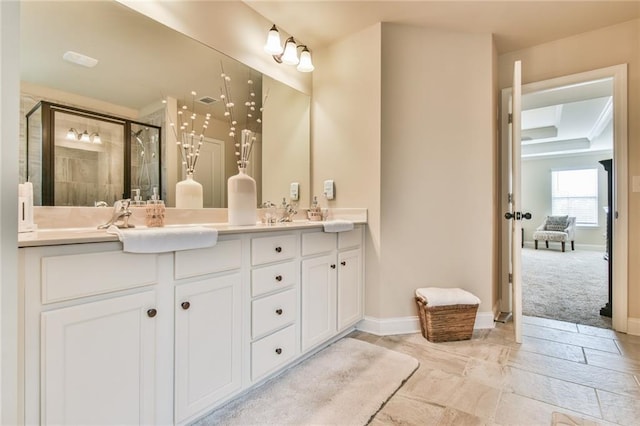 bathroom featuring a sink, a stall shower, baseboards, and double vanity