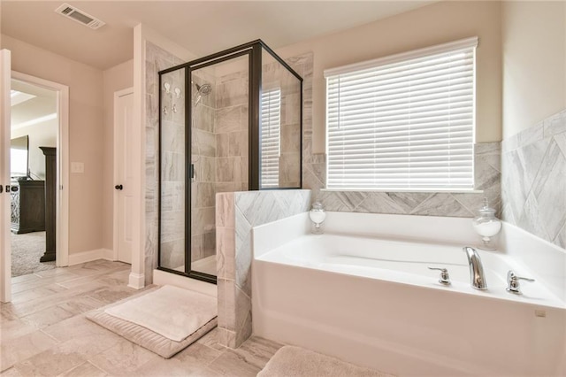 full bathroom featuring a shower stall, a bath, and visible vents