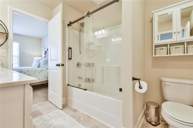 ensuite bathroom featuring baseboards, bath / shower combo with glass door, toilet, vanity, and ensuite bath