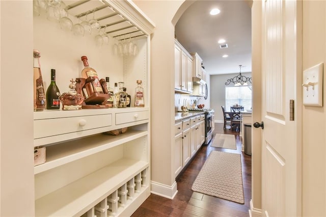 bar with baseboards, recessed lighting, arched walkways, dark wood-style flooring, and high end stove