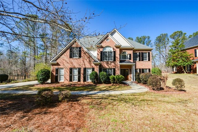 view of front of house with a front yard and brick siding