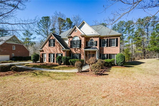 view of front of property featuring brick siding and a front yard