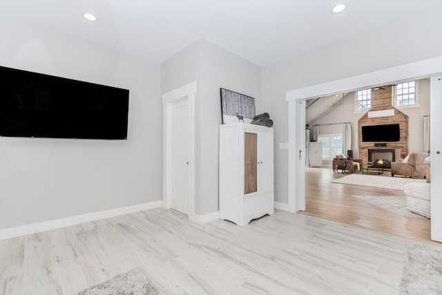 6044 Wade Orr Rd, Flowery Branch, GA 30542 - unfurnished living room featuring wood finished floors, a lit fireplace, and recessed lighting