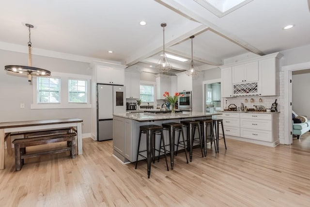 6044 Wade Orr Rd, Flowery Branch, GA 30542 - kitchen featuring refrigerator, light wood-style floors, a breakfast bar area, white cabinetry, and beam ceiling