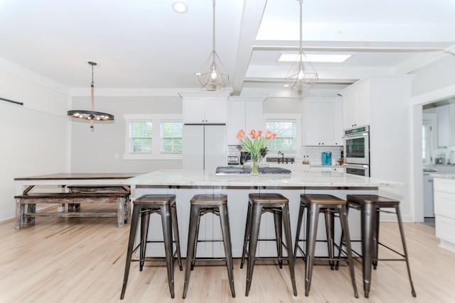 6044 Wade Orr Rd, Flowery Branch, GA 30542 - kitchen with appliances with stainless steel finishes, white cabinets, tasteful backsplash, light stone counters, and a spacious island