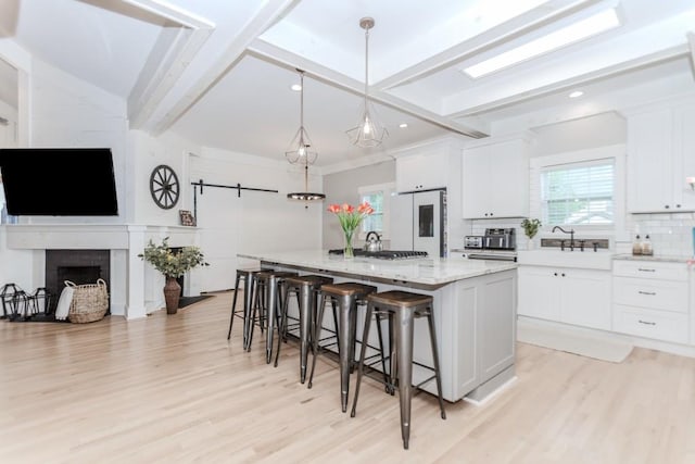 6044 Wade Orr Rd, Flowery Branch, GA 30542 - kitchen with tasteful backsplash, refrigerator, light wood-style flooring, a breakfast bar, and white cabinetry