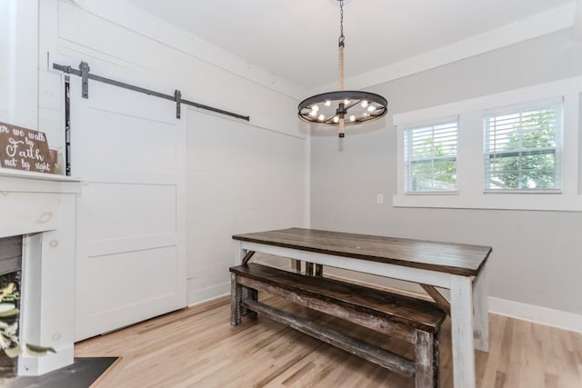 6044 Wade Orr Rd, Flowery Branch, GA 30542 - dining area featuring a barn door, light wood finished floors, and a chandelier