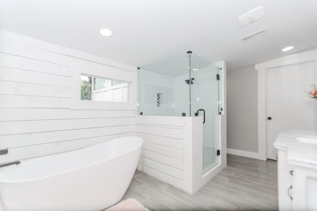 6044 Wade Orr Rd, Flowery Branch, GA 30542 - full bath featuring a soaking tub, a stall shower, recessed lighting, wood finished floors, and vanity