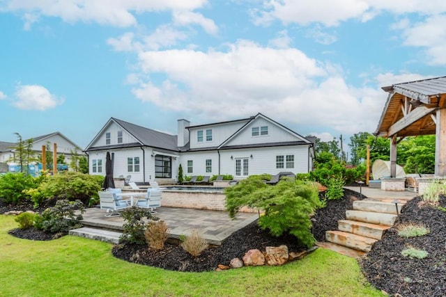 6044 Wade Orr Rd, Flowery Branch, GA 30542 - rear view of house with a patio area, a lawn, and a chimney