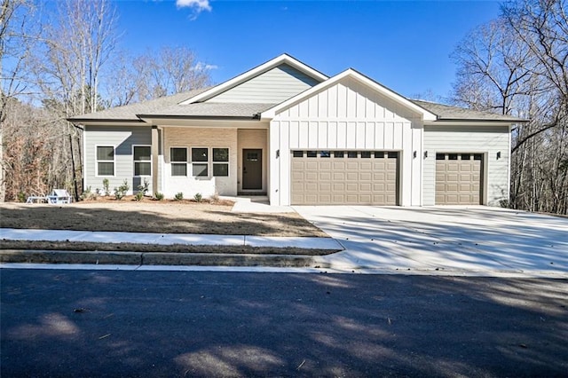 view of front of home with board and batten siding, roof with shingles, driveway, and a garage