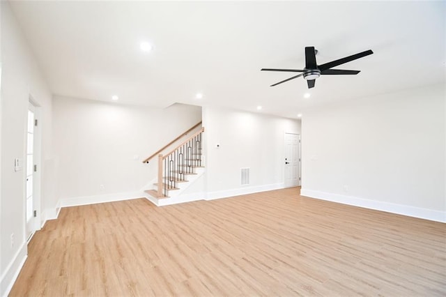 unfurnished living room with stairs, light wood finished floors, visible vents, and recessed lighting