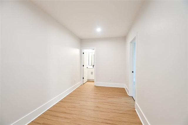 hall featuring light wood-type flooring and baseboards