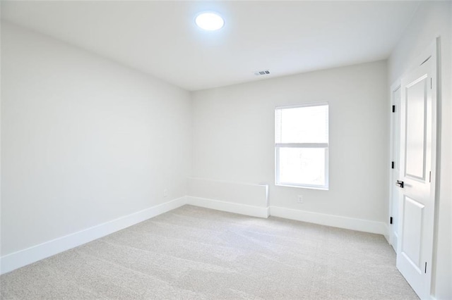 unfurnished room featuring light colored carpet, visible vents, and baseboards