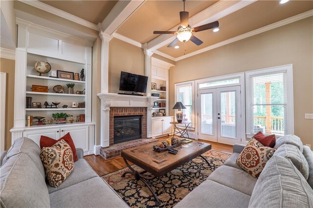 living room with ornamental molding, ceiling fan, and wood finished floors
