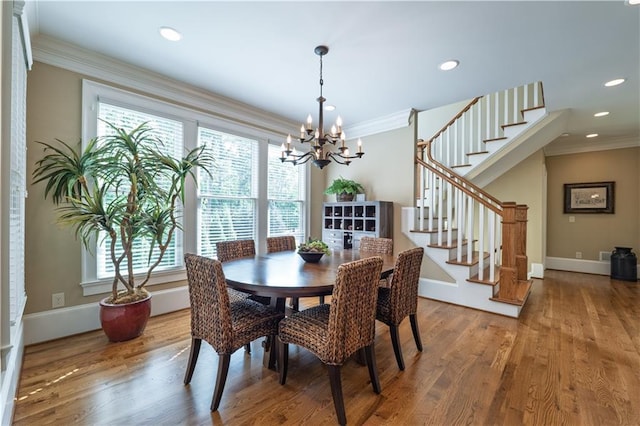 dining space with stairway, plenty of natural light, wood finished floors, and a notable chandelier