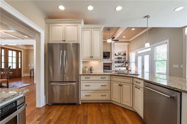 kitchen with french doors, appliances with stainless steel finishes, a sink, and wood finished floors