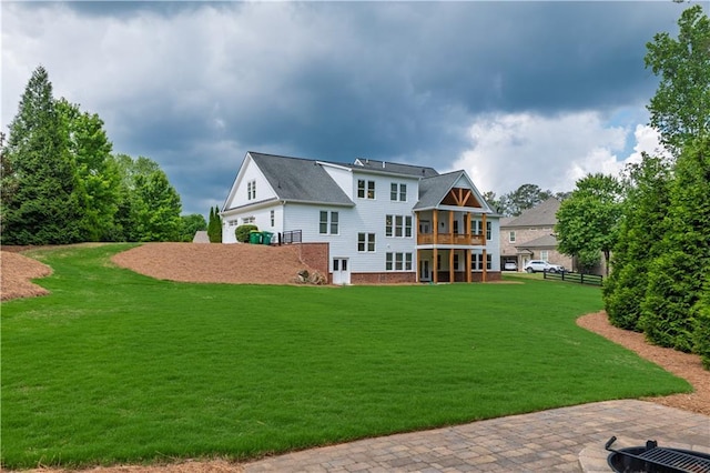 rear view of house with a lawn and fence