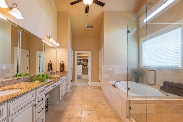 full bathroom with visible vents, a garden tub, double vanity, ceiling fan, and a sink