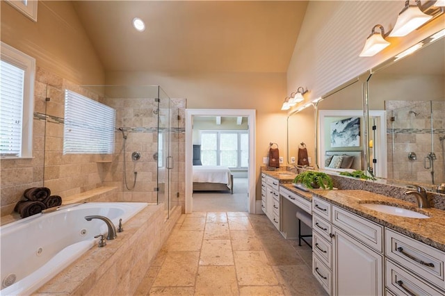 ensuite bathroom featuring a sink, ensuite bath, double vanity, a shower stall, and vaulted ceiling