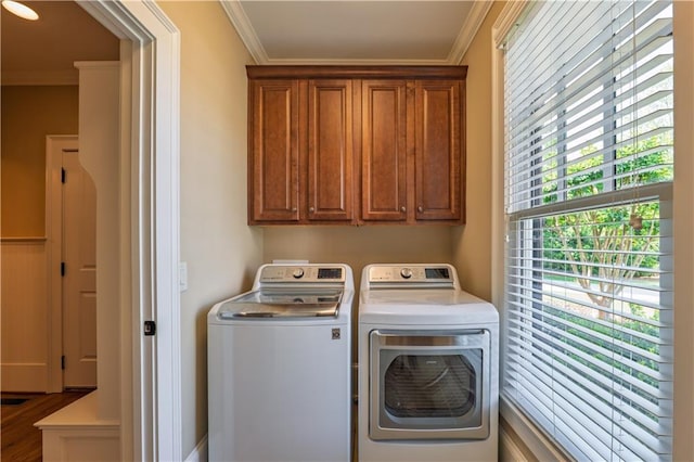 laundry room featuring cabinet space, ornamental molding, and washer and clothes dryer
