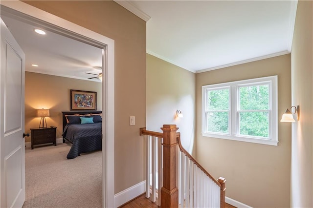 hallway featuring crown molding, recessed lighting, baseboards, and an upstairs landing