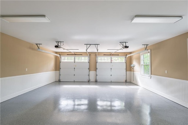 garage featuring a garage door opener and a wainscoted wall