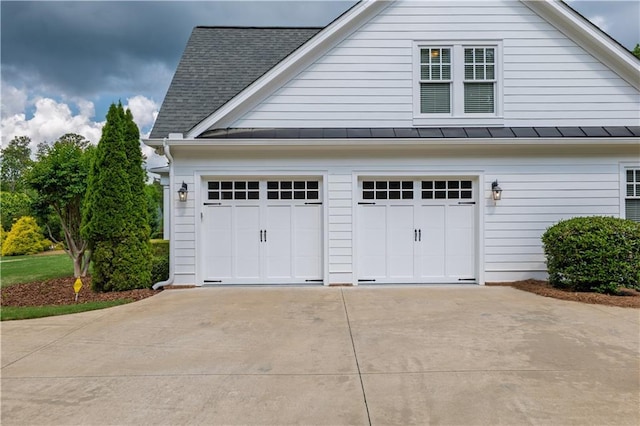 garage featuring concrete driveway