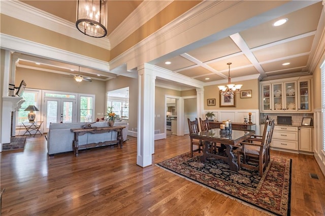 dining space featuring visible vents, ornamental molding, wood finished floors, coffered ceiling, and a notable chandelier