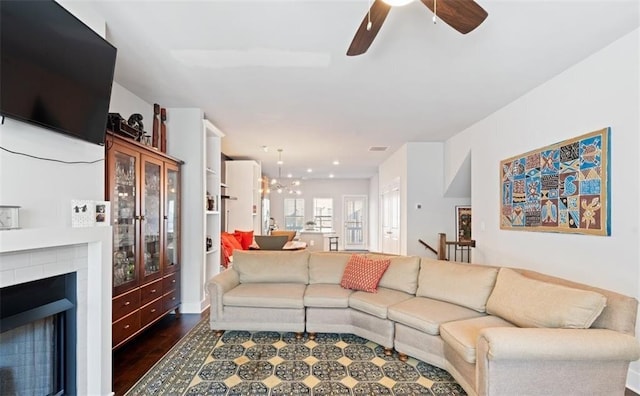 living room featuring ceiling fan with notable chandelier