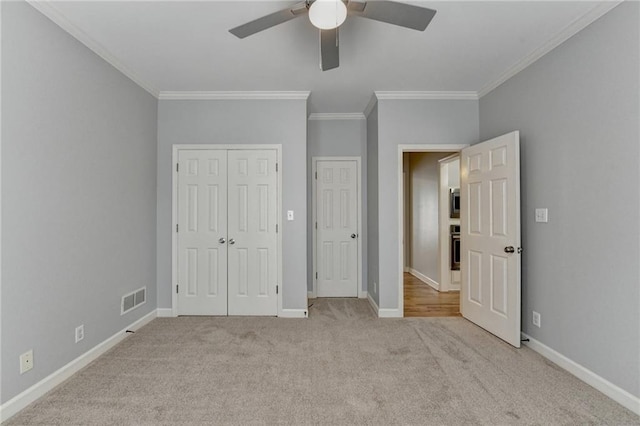 carpeted home theater with visible vents, a raised ceiling, crown molding, and a ceiling fan