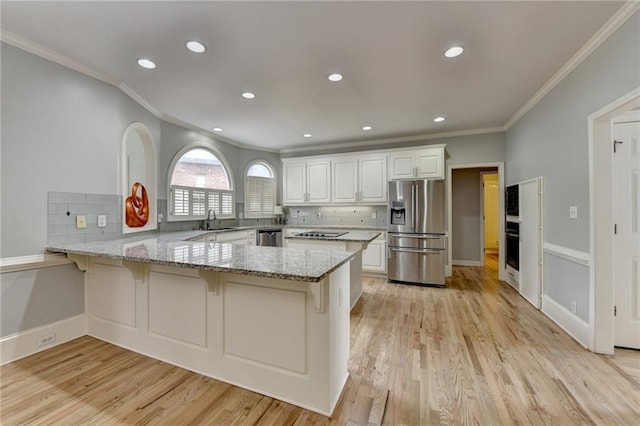 kitchen with a tray ceiling, baseboards, ceiling fan, and crown molding