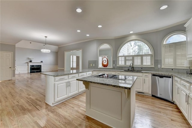 unfurnished living room with a ceiling fan, a tray ceiling, crown molding, baseboards, and light colored carpet