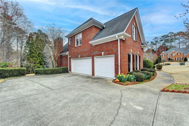 view of home's exterior featuring concrete driveway, brick siding, a garage, and a shingled roof