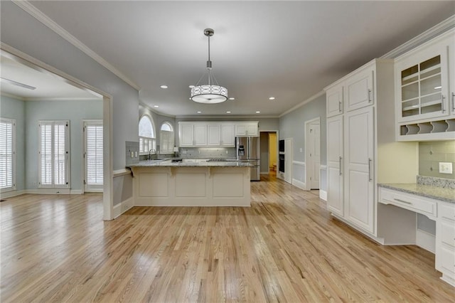 spare room featuring a ceiling fan, baseboards, visible vents, a raised ceiling, and light wood-type flooring