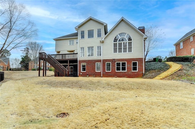 back of house with stairway, brick siding, a wooden deck, and a chimney