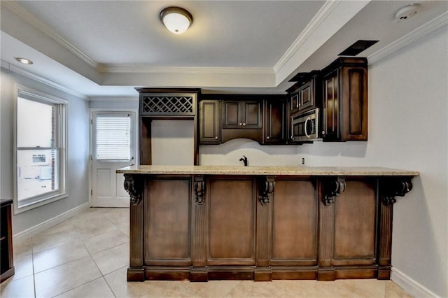 kitchen featuring light wood finished floors, ceiling fan, and light stone countertops