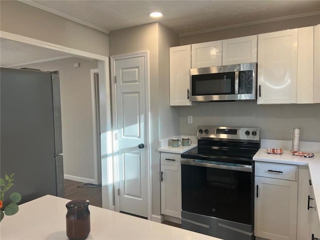 kitchen featuring stainless steel appliances, white cabinetry, dark hardwood / wood-style floors, and ornamental molding