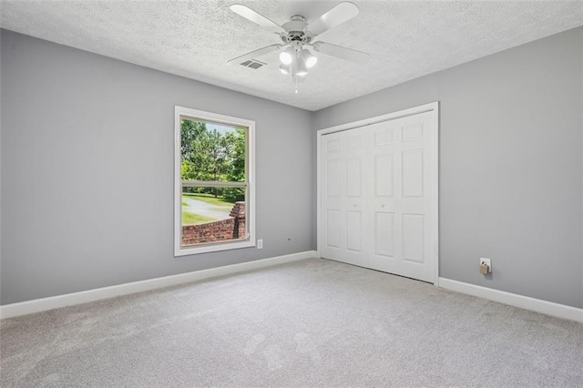 12 Windsor Way, Newnan, GA 30263 - unfurnished bedroom with carpet floors, a closet, a textured ceiling, and a ceiling fan