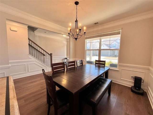 dining space featuring dark hardwood / wood-style flooring, crown molding, and an inviting chandelier