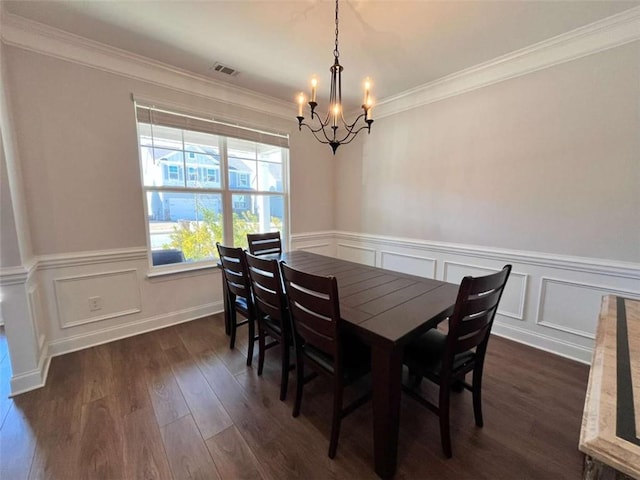 dining area with ornamental molding, a notable chandelier, and dark hardwood / wood-style flooring