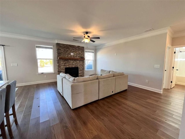 living room with ceiling fan, a fireplace, ornamental molding, and dark hardwood / wood-style flooring