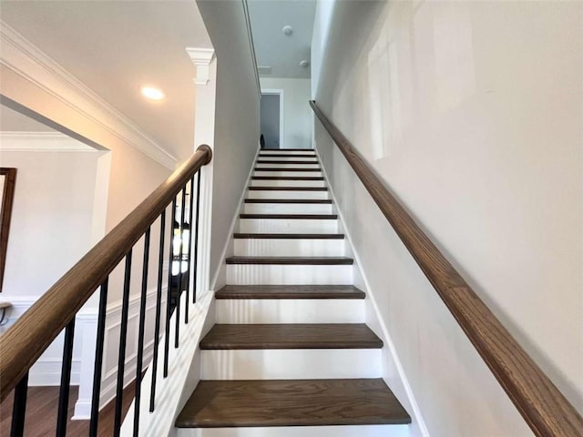 staircase featuring crown molding and wood-type flooring